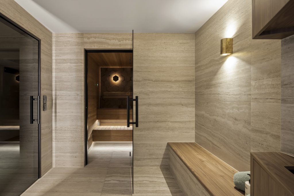 Stone sauna with wooden bench seat and bronze lights at TH7
